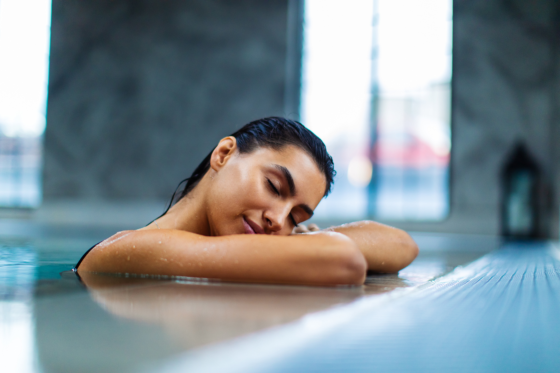 beautiful young woman relaxing on indoors poolside